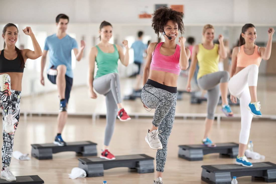 Gruppe beim Step-Training mit Instruktorin
